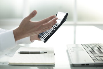 Man counts on a calculator in the office