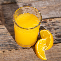 Orange fruit juice on wooden background