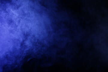 Obraz na płótnie Canvas Smoke illuminated in purple on a black background