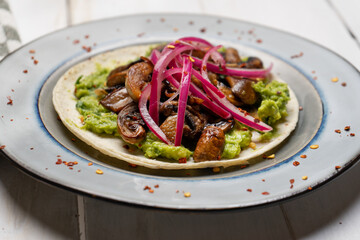 Mushroom and guacamole tacos on white background. Mexican food
