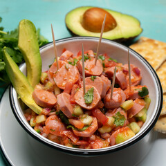 Wieners cocktail with avocado and ketchup on turquoise background. Mexican food