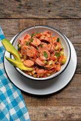 Wieners cocktail with avocado and ketchup on wooden background. Mexican food