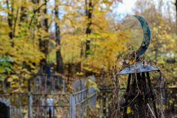 Naklejka premium religious symbol of Islam iron steel crescent moon near the grave in the cemetery