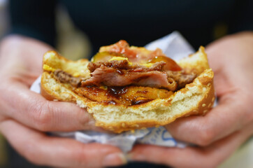 Woman squeezing hamburger in fast food restaurant.