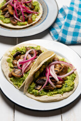 Mushroom and guacamole tacos on white background. Mexican food