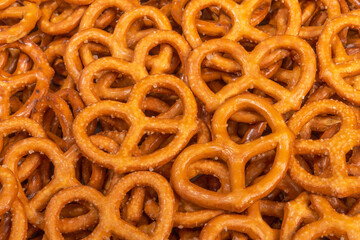 Salted Bavarian pretzel close-up, beer snack - web banner. Mini pretzel, fresh baked goods. Background or texture of fresh baked pastry. Background of pretzels.