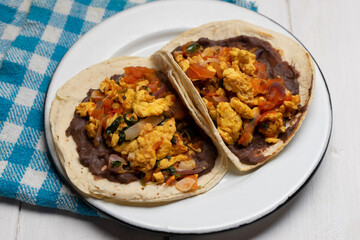 Scrambled eggs and refried beans tacos on white background. Mexican food