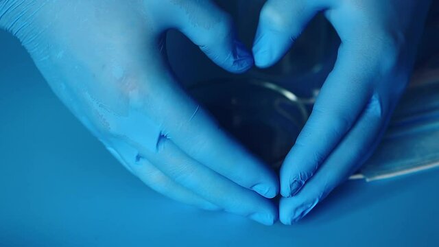 Doctor's hands in gloves show the shape of the heart. Love and gratitude to doctors.