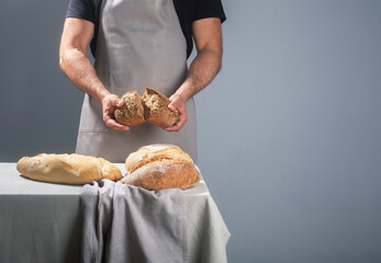 Baker holding freshly baked bread over table