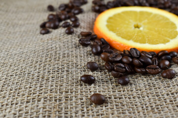 Pokrojone plasterki pomarańczy i ziarna niezmielonej kawy.