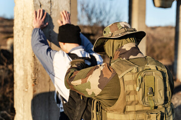 Back view of man in uniform unknown military soldier or special forces police arresting and...