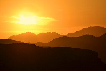 Beautiful sunset in the Wadi Rum desert. The early evening sun illuminates the mountains and valleys.