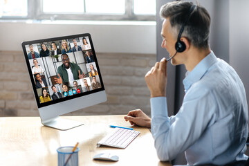 Online conference, video call. Successful adult businessman have conversation with multiracial...