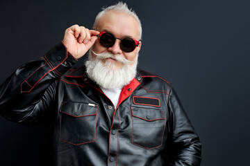 confident brutal male in leather jacket and eyeglasses posing at camera, looking cool and modern....