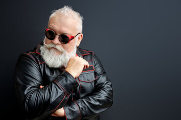 serious gray-haired mustache bearded man in black leather jacket, eyeglasses posing isolated over...