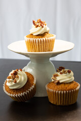 tres madalenas de nuez con crema batida con soporte blanco en fondo blanco
