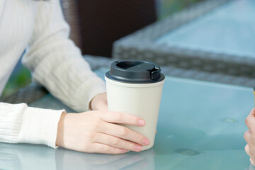 カフェでコーヒーを飲む女性　顔無し
