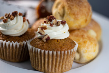 panes horneados en plato blanco con fondo negro, cupcake de nuez