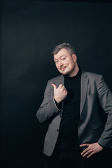 Presenting product, sale, discount, special offer concept. Business man with welcoming gesture on black background, free space