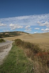 Obraz premium Tuscany, Italy. Rural road towards medieval town.