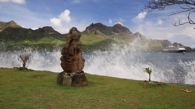 Nuku Hiva, Marquesas Islands. Stone Tiki sculpture and sea wave.