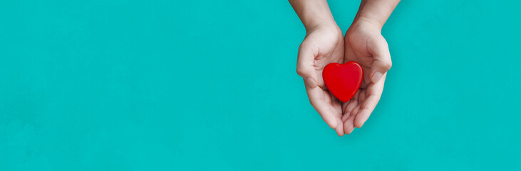 person holding a heart in his hands with blue background