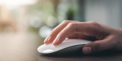 Close up of hand using on white mouse and clicking on office table.