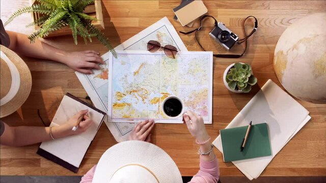 Top view of young couple with maps planning vacation trip holiday, desktop travel concept.