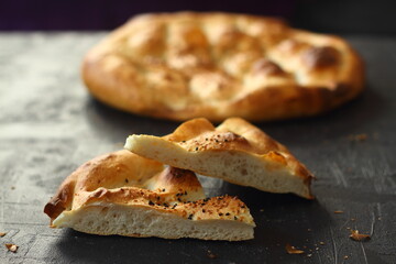 Slices of Ramadan Pita (Ramazan Pidesi) Traditional Turkish bread for holy month Ramadan on black background. Ramadan concept.