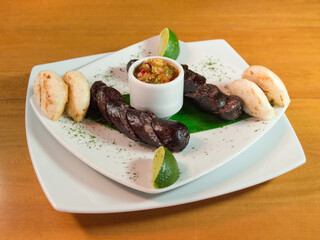 Blood sausage accompanied with arepas and lemon
