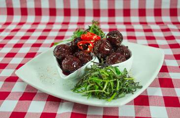 Meatloaf in wine with checkered tablecloth and vegetables
