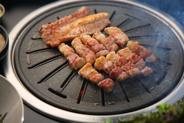 Grilled pork on an iron plate. 철판위에서 노릇노릇 익어가고 있는 돼지고기
