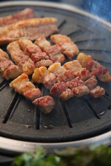 Grilled pork on an iron plate. 철판위에서 노릇노릇 익어가고 있는 돼지고기