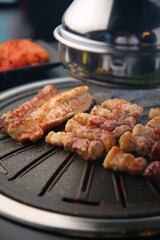 Grilled pork on an iron plate. 철판위에서 노릇노릇 익어가고 있는 돼지고기