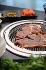 Marinated ribs are being grilled on charcoal.