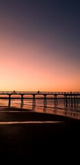 Fototapeta na wymiar two people riding a bicycle on the jetty, beautiful sunset with a jetty at Hervey Bay, Queensland, Australia, 