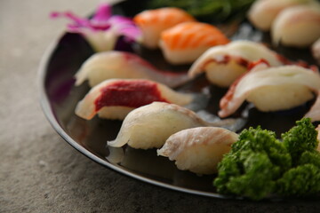 회색배경에 형형색색의 일본식 초밥 세트 It's a Japanese sushi set with a gray background.