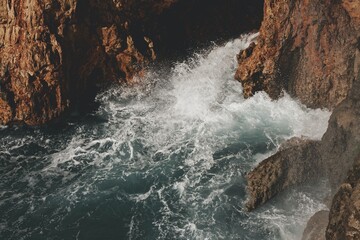 angry waves and waterfalls in the blue sea water ocean coast rocks landscape rock beach  nature cliff blue sky shore surf coastline rocky waterfall 