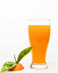 orange juice in glass with pieces of oranges and green leafs on black background. Summer and freshness concept