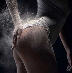 Sporty woman coating her body with powder chalk