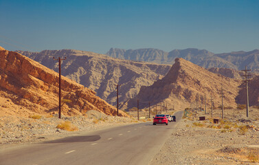 Cars passing in the scenic desert road on the Jebel Jais mountain in the UAE 