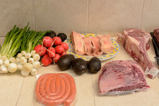 Mesa con ingredientes y cortes de carne para parrillada