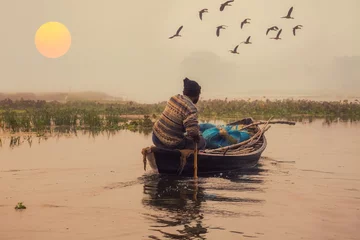 Foto op Canvas Indian fisherman takes his boat out into the river at sunrise with view of misty rural landscape © Roop Dey