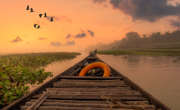 Scenic river sunset with rural landscape as viewed from a fishing boat. Photograph shot at Burdwan district in West Bengal, India