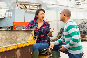 Farm workers have a dialogue next to the tractor