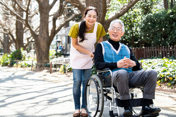 車椅子に乗った高齢者と女性福祉士・ポートレート