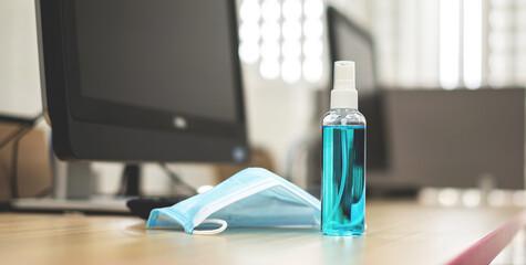 Alcohol spray bottles and medical surgical masks on work desk. Hygiene concept. prevent the spread of germs and bacteria and avoid infections coronavirus or covid-19