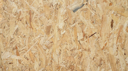 OSB sheet is made of brown wood chips pressed together into a wooden floor.