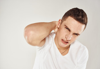 Nice guy in a white T-shirt on a light background cropped view portrait close-up