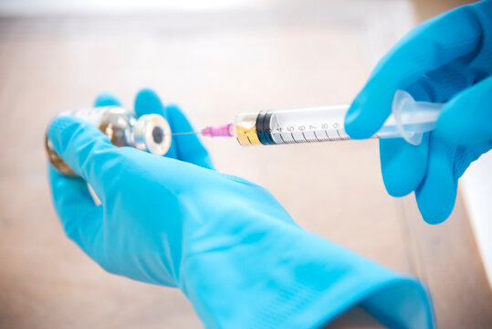 COVID-19 Vaccine In Researcher Hands,doctor Holds Syringe And Bottle With Vaccine For Coronavirus Cure. Concept Of Corona Virus Treatment, Injection, Shot And Clinical Trial During Pandemic.